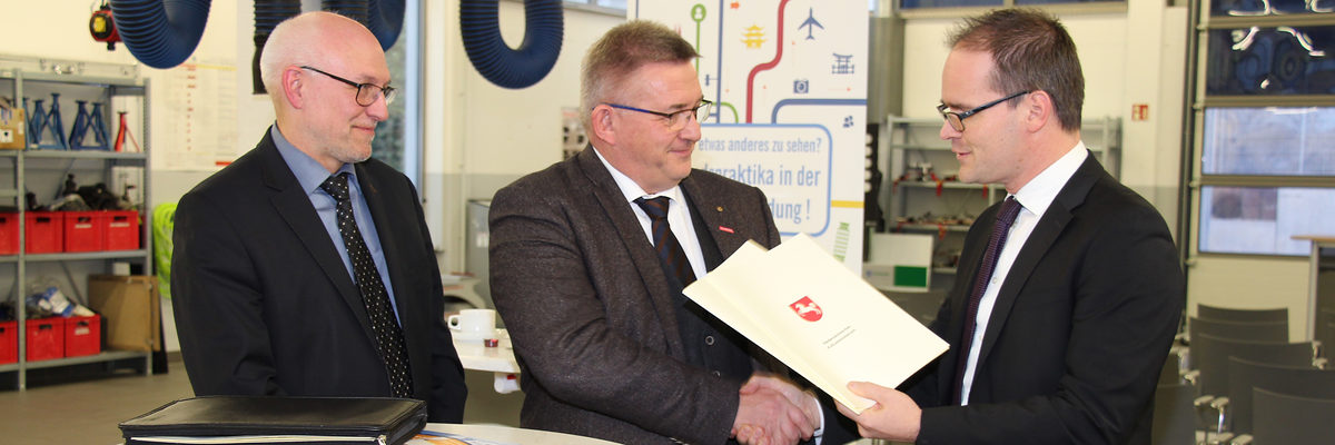 Der Niedersächsische Kultusminister Grant Hendrik Tonne (rechts) überreicht die Bescheide an Hauptgeschäftsführer Eckhard Sudmeyer (links) und Kammerpräsident Detlef Bade (mitte). TZH Braunschweig, 2018, Kultusminister Grant Hendrik Tonne, Technologiezentrum, Förderbescheid, ÜLU