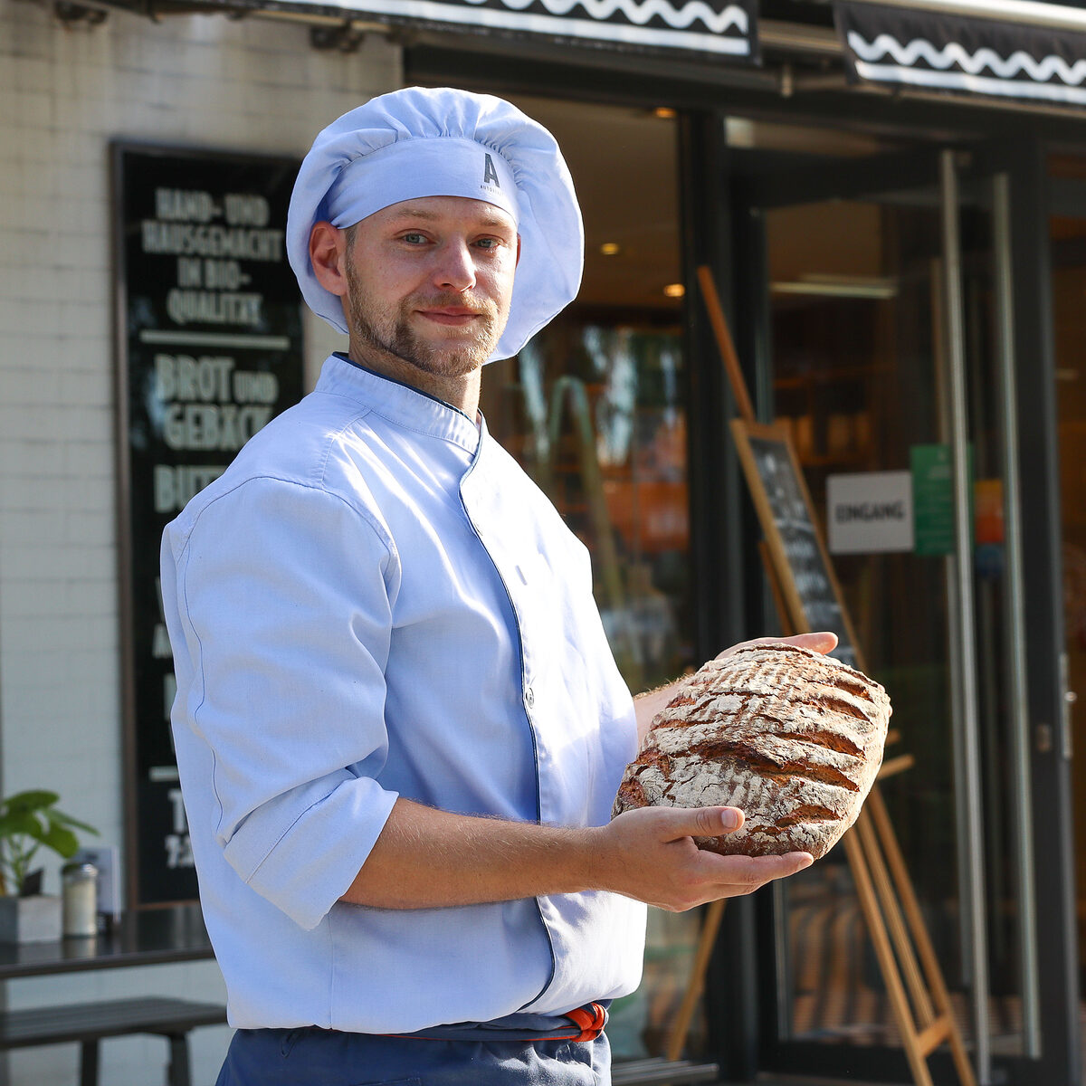 Bäckermeister Patrick Gerecke mit einem Krustenbrot in der Hand. 