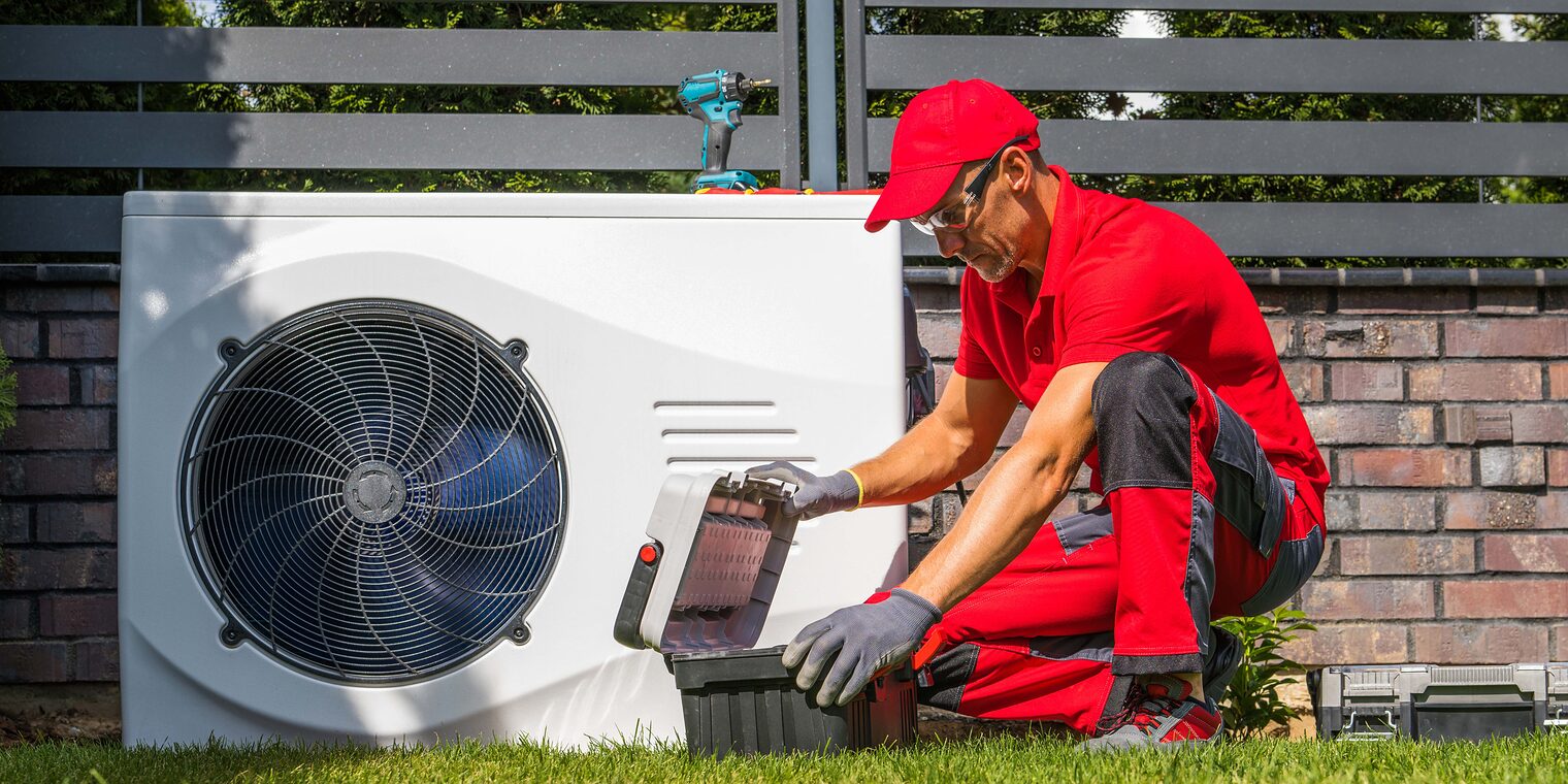 Symbolbild Handwerker installiert Wärmepumpe