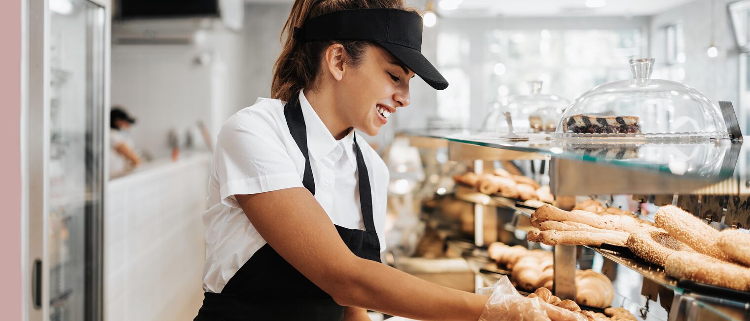 Symbolbild Bäckereifachverkäuferin räumt Ladentheke ein