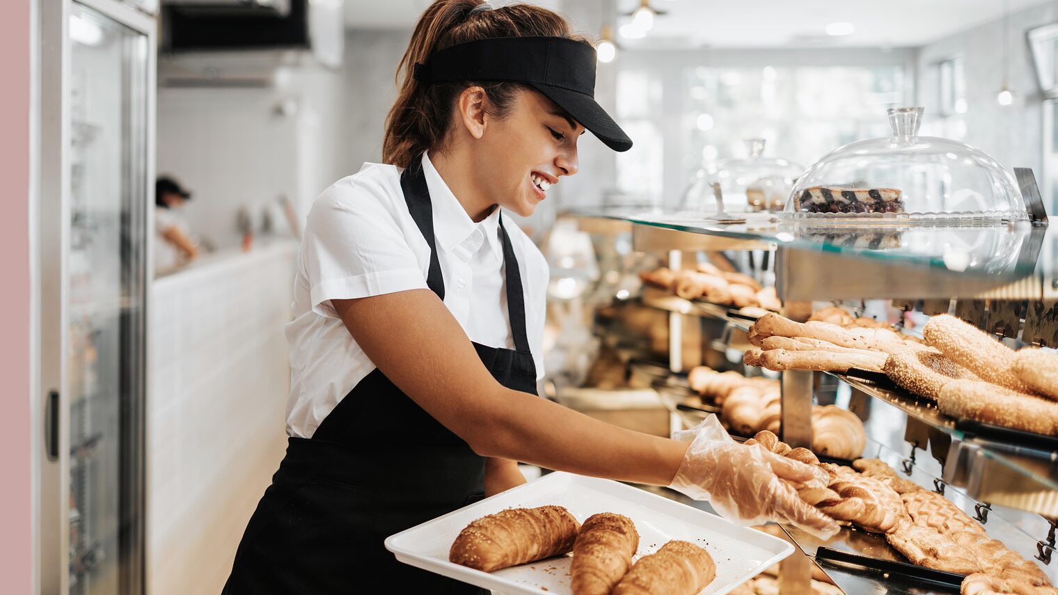 Symbolbild Bäckereifachverkäuferin räumt Ladentheke ein