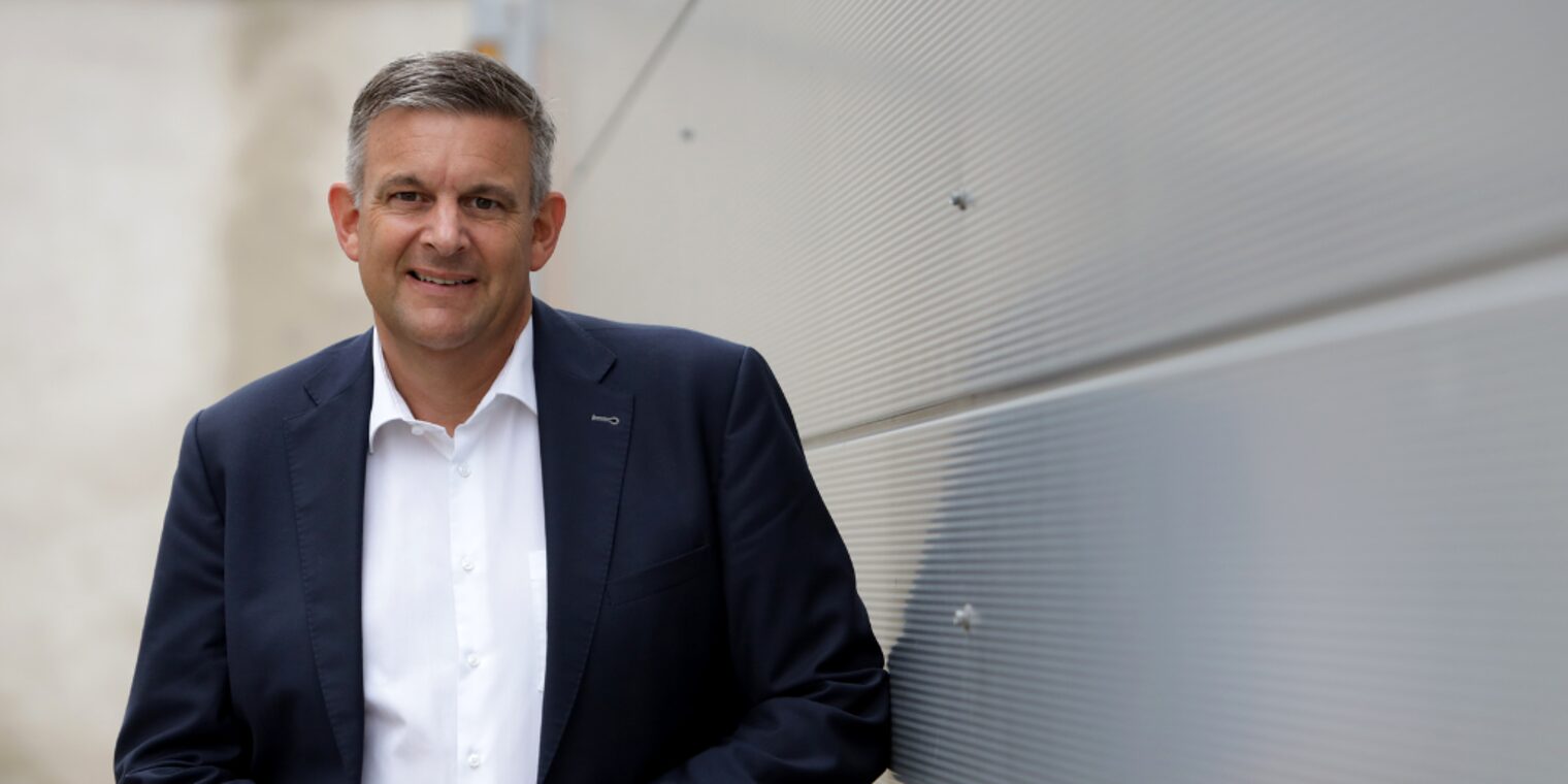 Matthias Steffen, Hauptgeschäftsführer der Handwerkskammer, im Anzug vor moderner Wand stehend und freundlich blickend.