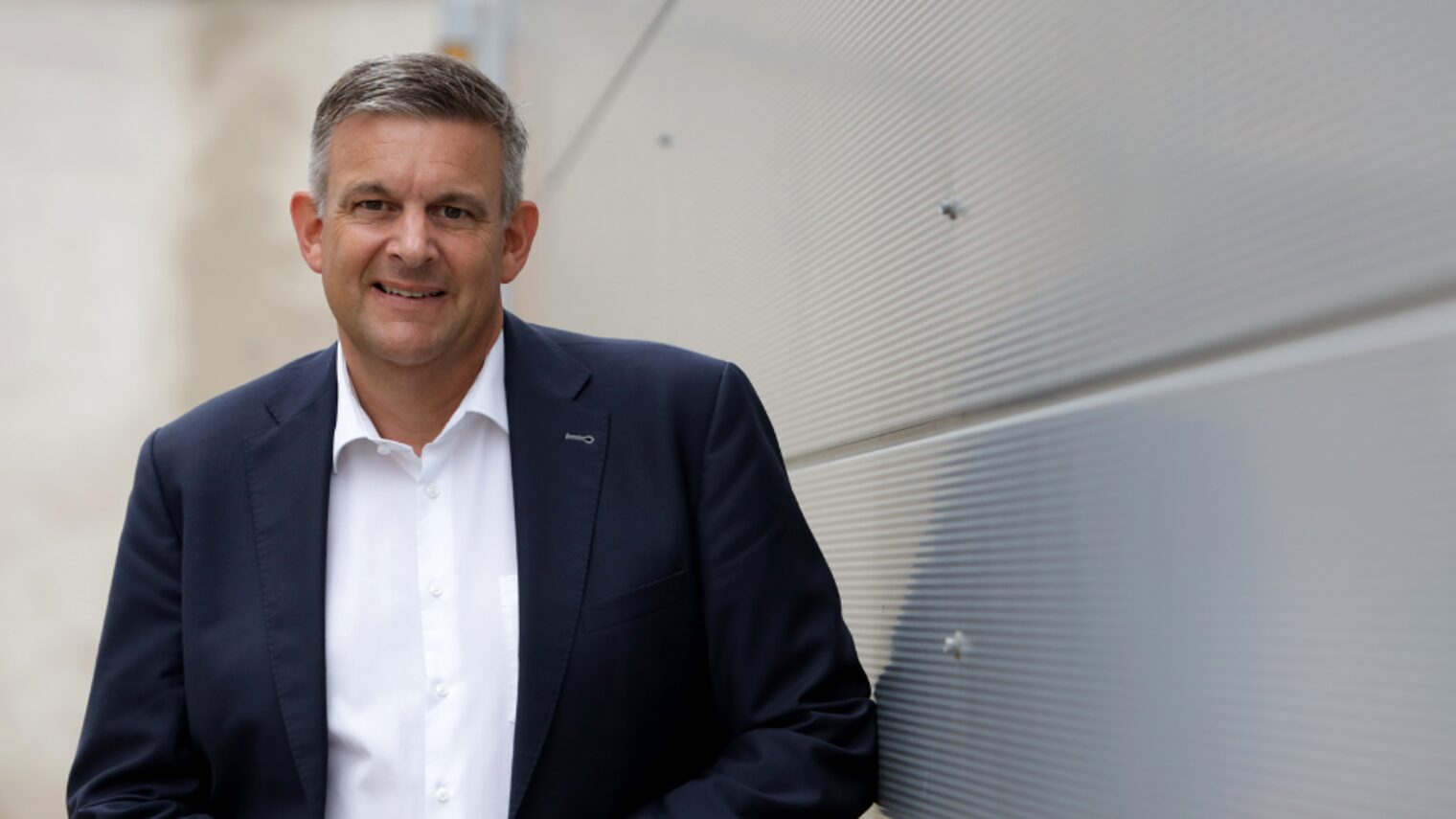 Matthias Steffen, Hauptgeschäftsführer der Handwerkskammer, im Anzug vor moderner Wand stehend und freundlich blickend.
