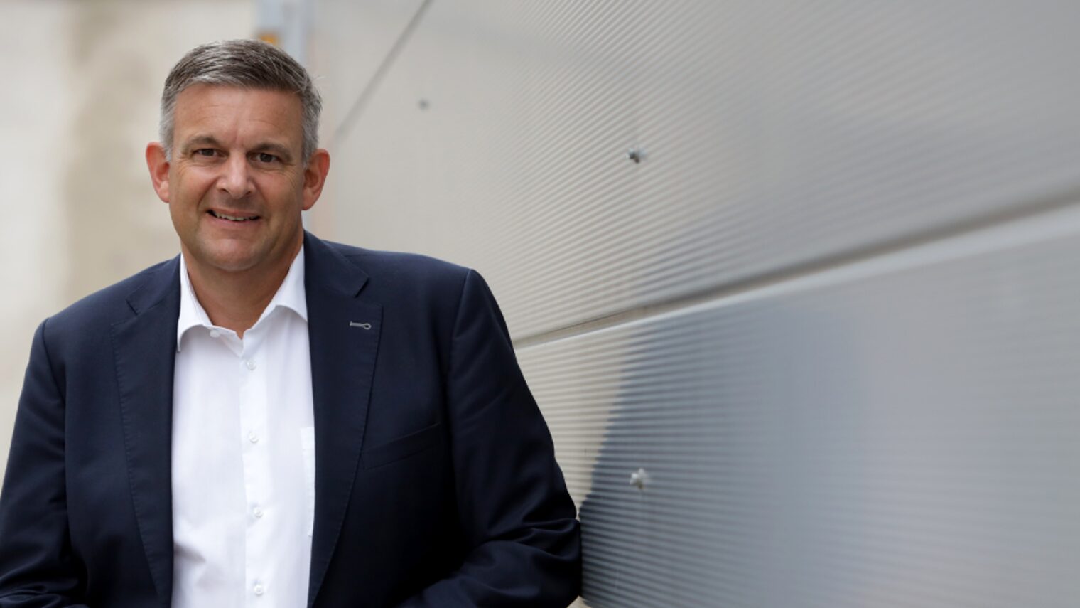 Matthias Steffen, Hauptgeschäftsführer der Handwerkskammer, im Anzug vor moderner Wand stehend und freundlich blickend.