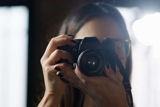 Frau mit dunklem Nagellack fotografiert mit Spiegelreflexkamera im Gegenlicht