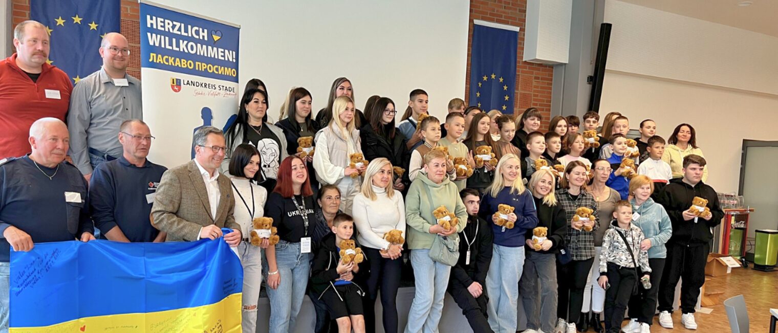 Teilnehmergruppe der Ukraine-Kinderfreizeit im TZH Stade Gruppenfoto der Teilnehmerinnen und Teilnehmer der Ukraine-Kinderfreizeit 2025 im Technologiezentrum Stade mit Willkommensbanner