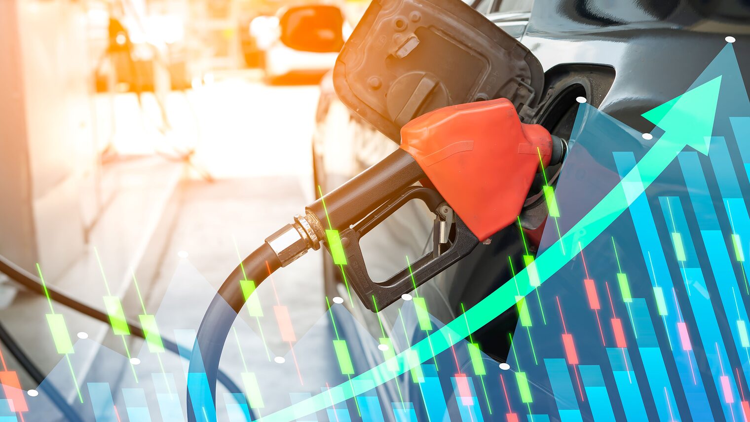 Rote Zapfpistole beim Betanken eines Autos, überlagert von Börsengrafiken und einem steil ansteigenden Pfeil als Symbol für steigende Spritpreise und Kostenbelastungen.