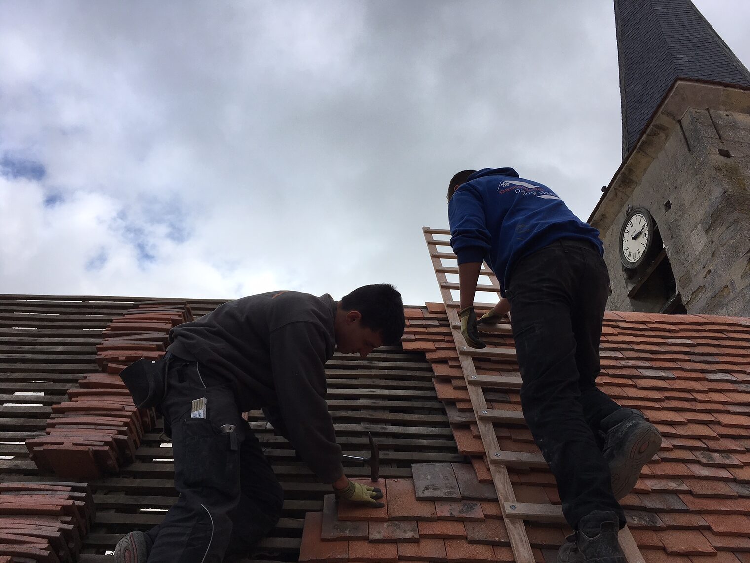 Marian Plitzko (links im Bild) und Jason Fiesel decken das Dach der Kirche in Livilliers bei Paris neu ein.
