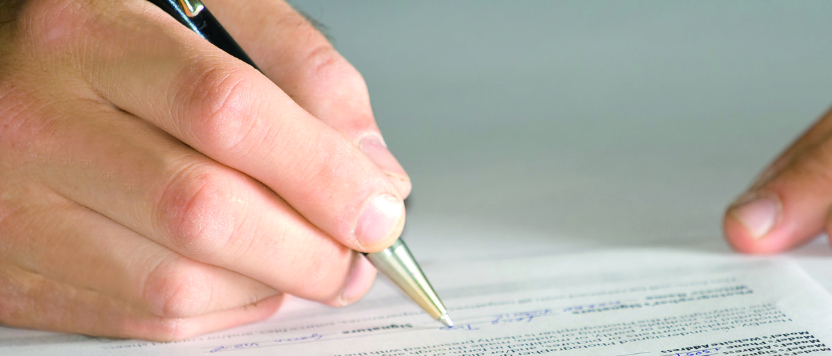 Teilen Sie uns Ihre Kommunikationsdaten online mit. Hand mit Stift füllt Formular aus.
