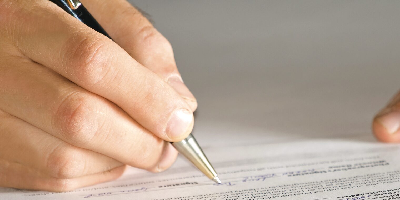 Teilen Sie uns Ihre Kommunikationsdaten online mit. Hand mit Stift füllt Formular aus.