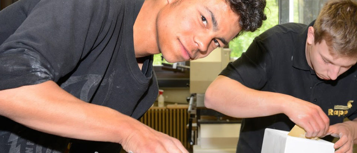 Migrant in Tischlerausbildung Zwei Auszubildende arbeiten in der Tischlerwerkstatt.