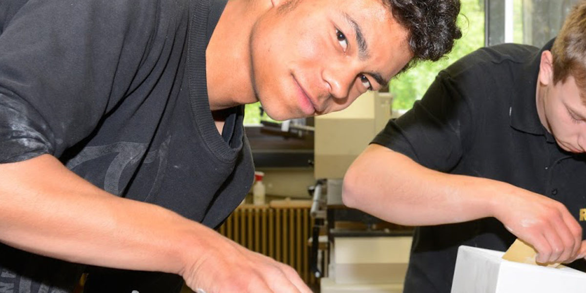 Migrant in Tischlerausbildung Zwei Auszubildende arbeiten in der Tischlerwerkstatt.