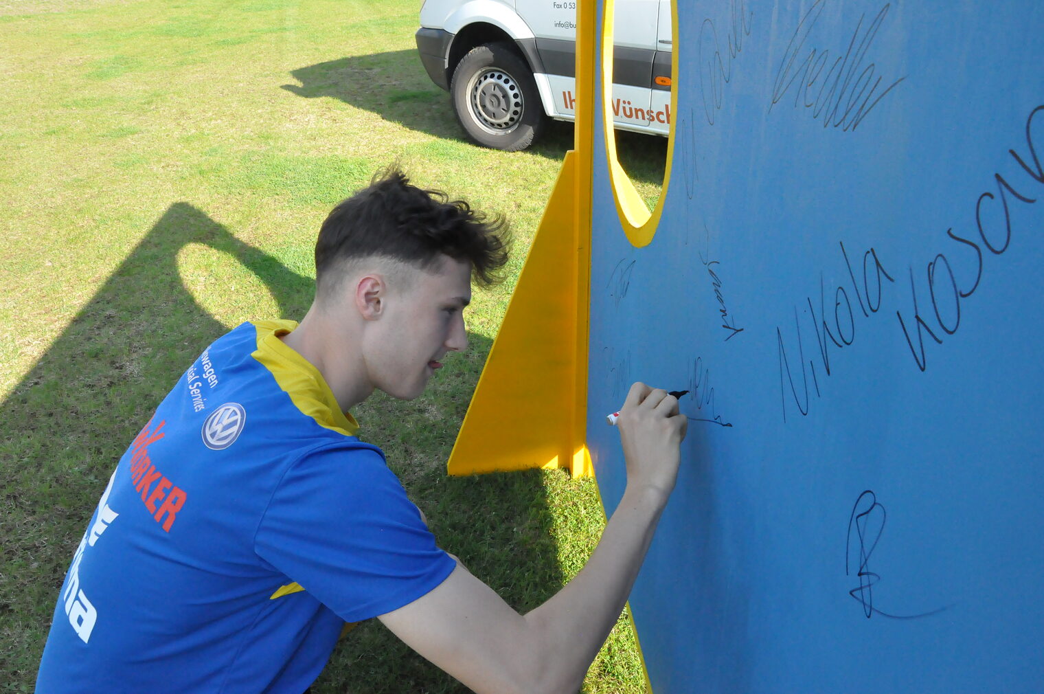 Ein Spieler unterschreibt auf der Torwand.