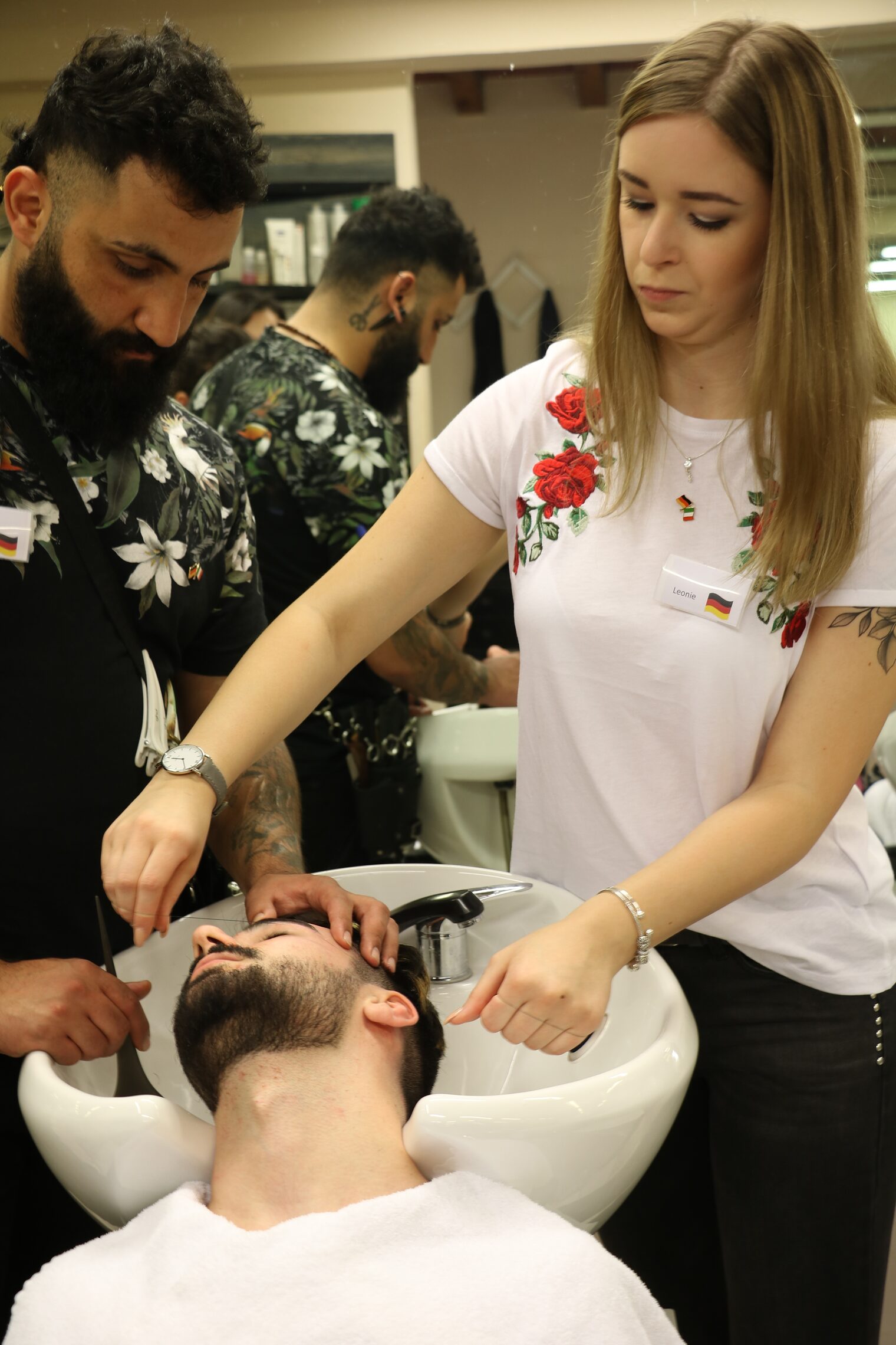 Bartpflege mit dem Faden. Burhan Mustafa (links) und Leonie Krämer (rechts) arbeiten gemeinsam an einem italienischen Kunden
